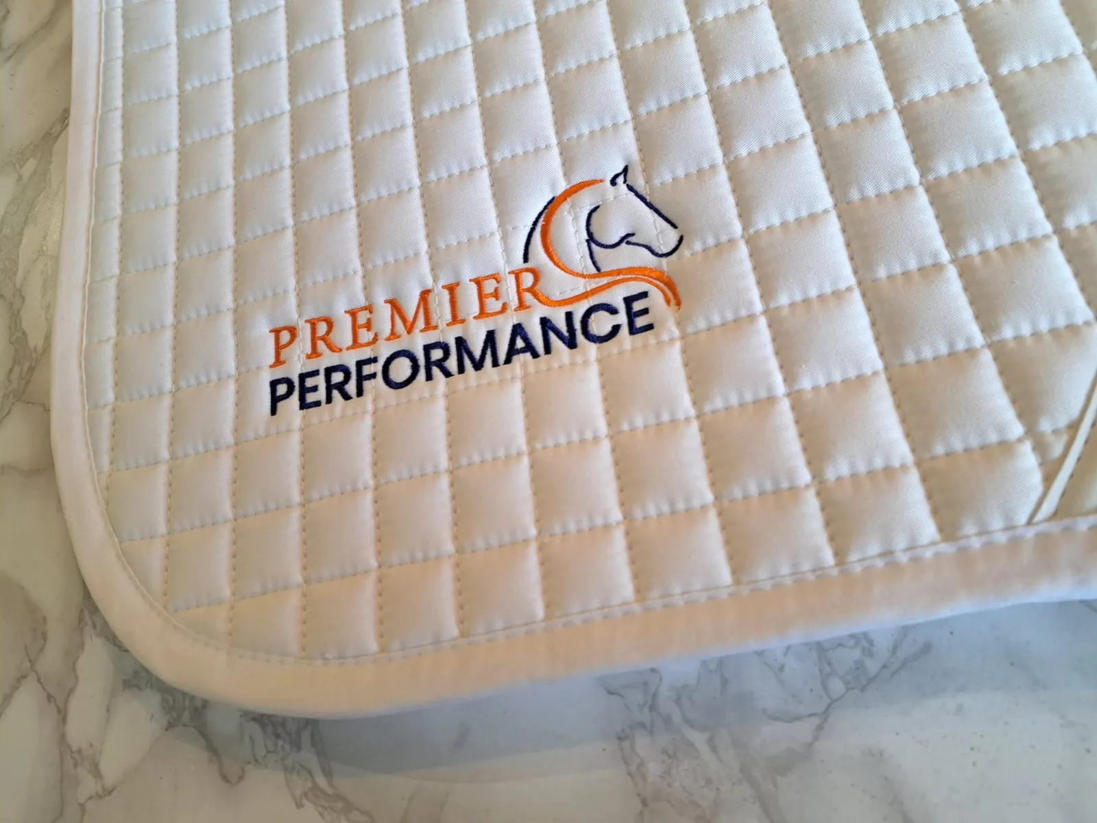 White Premier Equine numnah with sponsorship embroidery